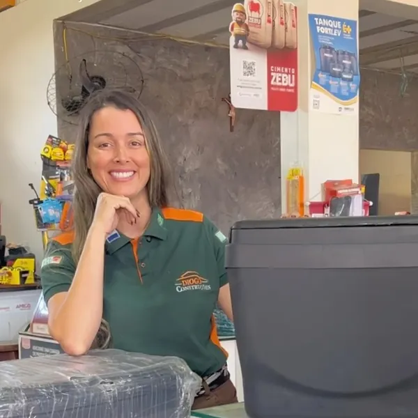 Atendente sorridente no balcão da Diogo Construções